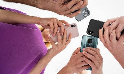 Close-up of multiple people holding and using smartphones, highlighting the latest mobile technology and smartphone camera features.