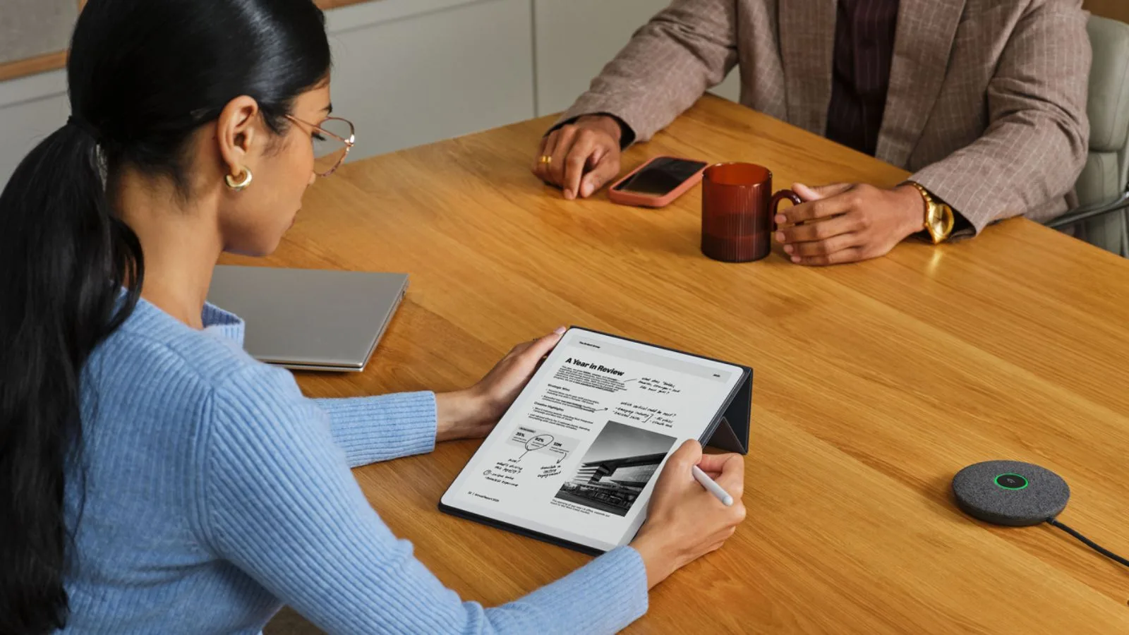 People discuss document at conference table.
