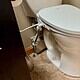 Toilet with a smart lid in a bathroom setting, connecting to power for advanced features like automatic lid opening. Modern bathroom technology integrating smart toilet accessories for enhanced hygiene and convenience.