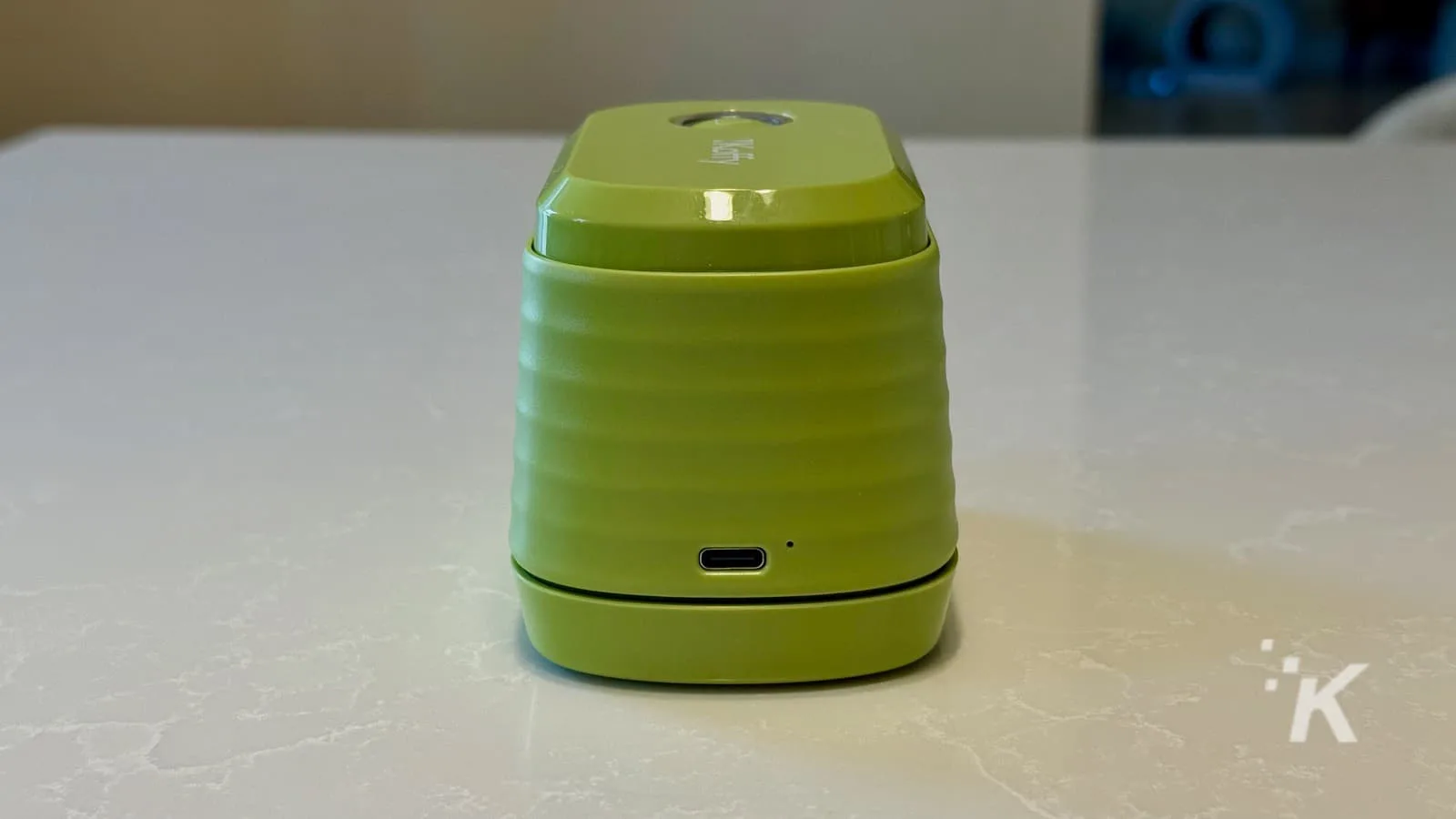 Green Bluetooth speaker on a marble table.