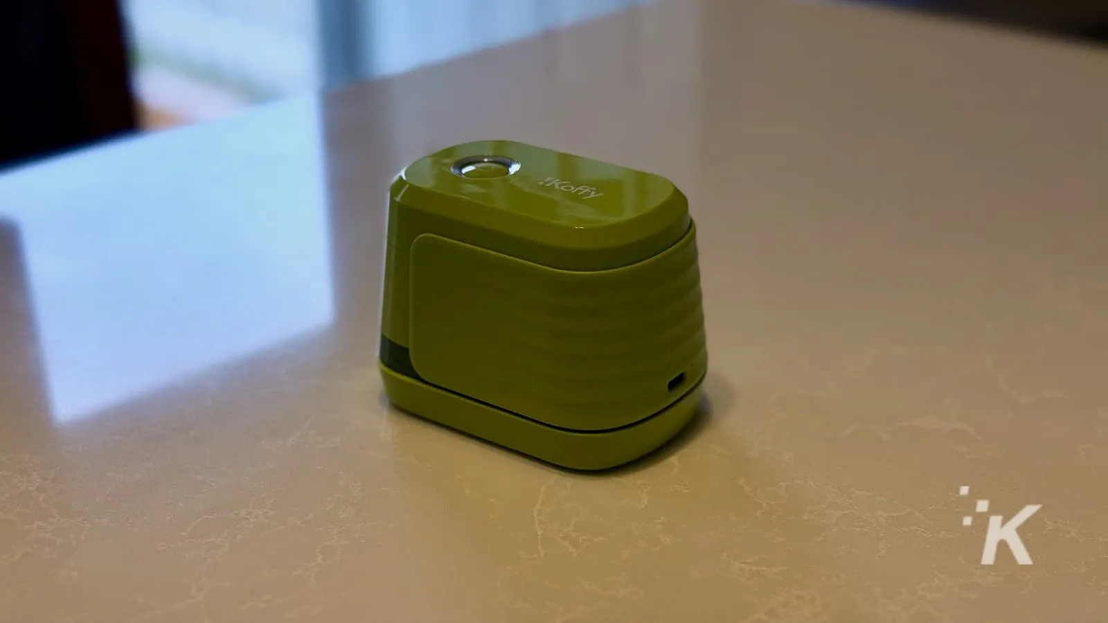 Green automatic can opener on countertop