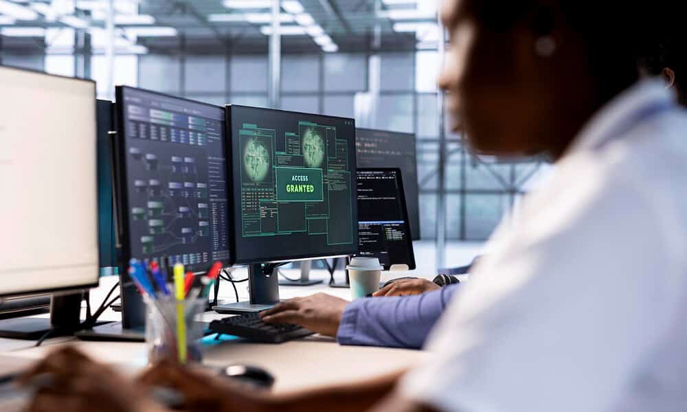 AI-driven cybersecurity expert analyzing digital security systems on multiple monitors in a modern office.