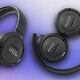 JBL over-ear wireless headphones with foldable design on a purple gradient background.