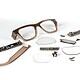 Disassembled smart glasses with electronic components and broken lenses on a white background.