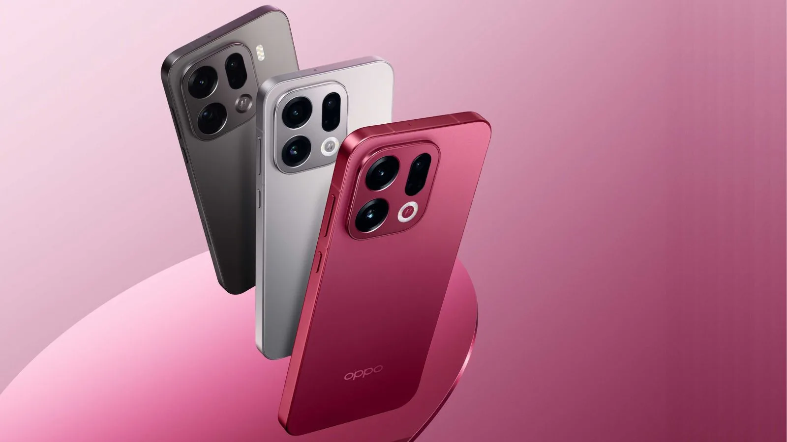 Three smartphones in different colors on pink background.