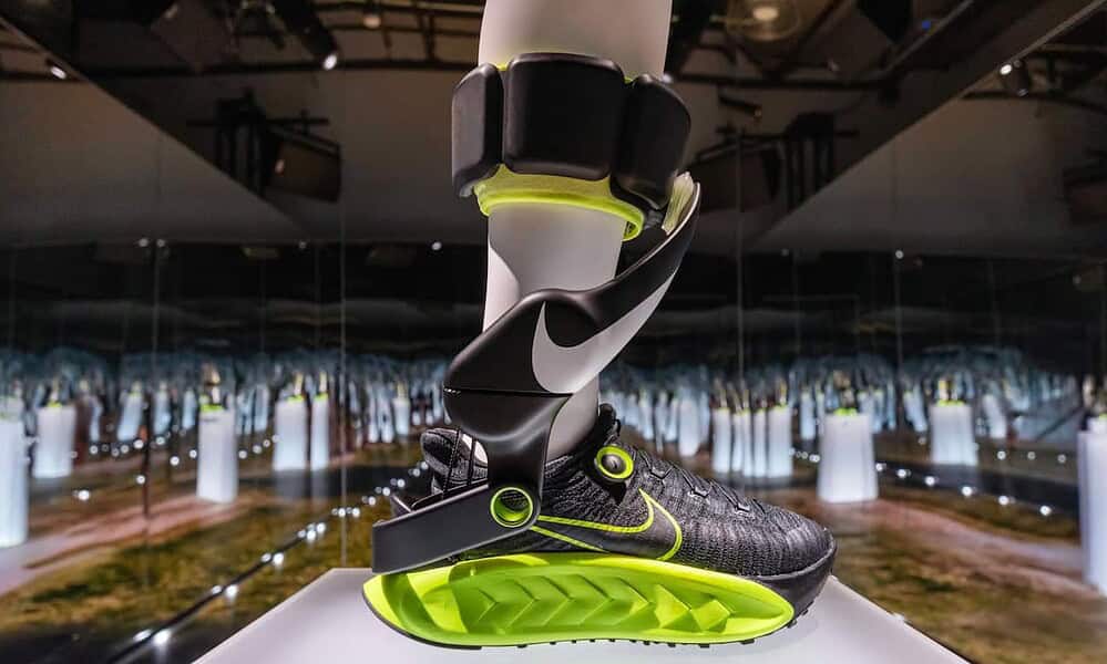 High-tech Nike smart running shoe with attached fitness tracker, displayed in a futuristic exhibit at KnowTechie showcasing innovative wearable technology.