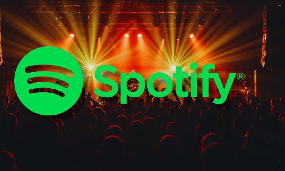 Spotify logo over a concert crowd with stage lights and colorful effects.