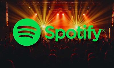 Spotify logo over a concert crowd with stage lights and colorful effects.