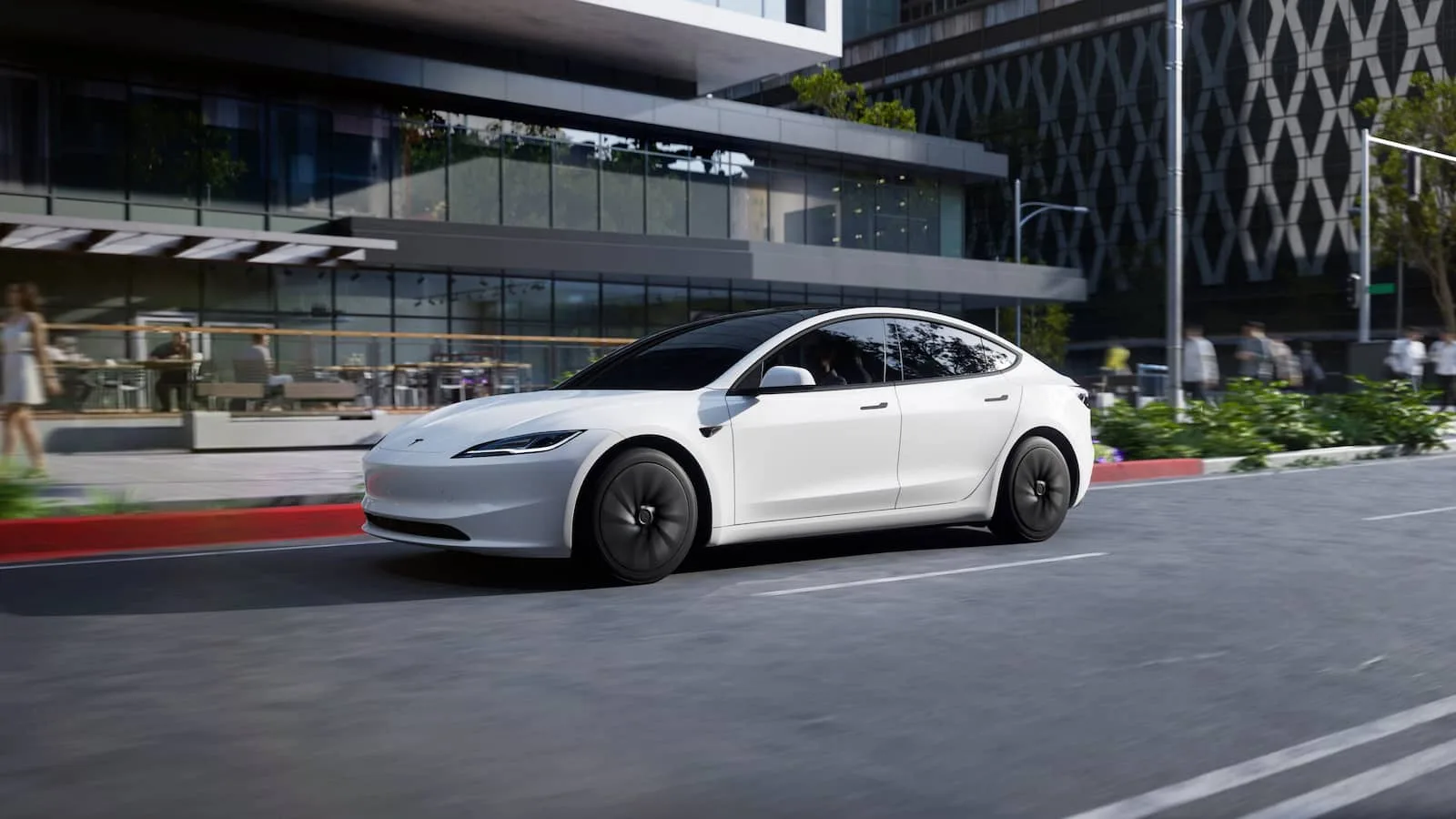White electric car driving on city street.