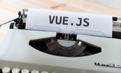 Typewriter with a sheet of paper displaying "VUE.JS" for web development and JavaScript frameworks.