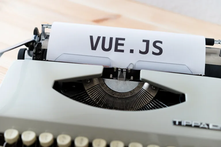 Typewriter with a sheet of paper displaying "VUE.JS" for web development and JavaScript frameworks.