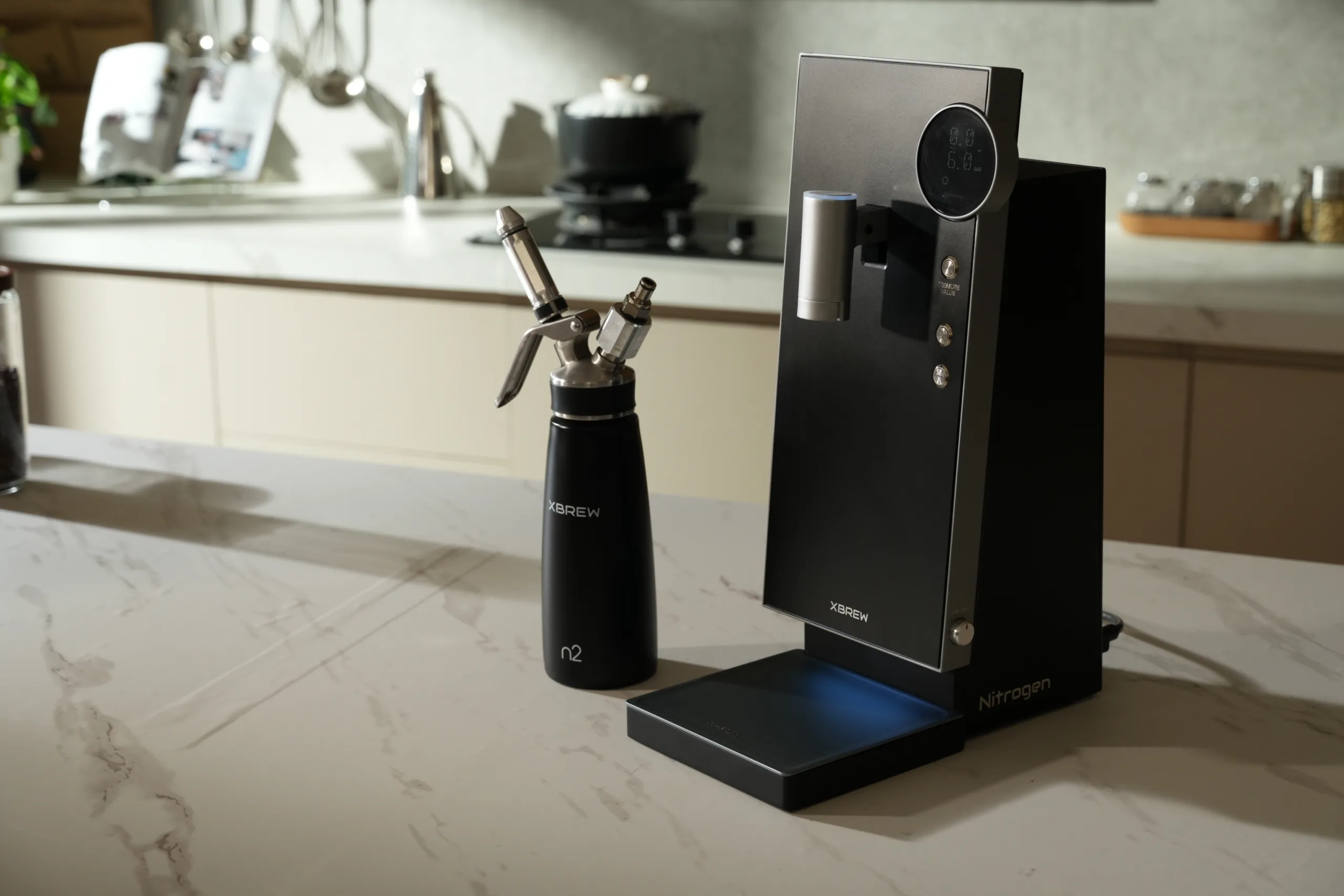 Nitrogen coffee infuser with XBREW branding on a kitchen countertop, modern and sleek device for nitrogen-infused beverages, with a small nitrogen bottle nearby in a bright, contemporary kitchen setting.