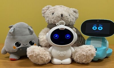Plush toys and robots with smiling faces on display.