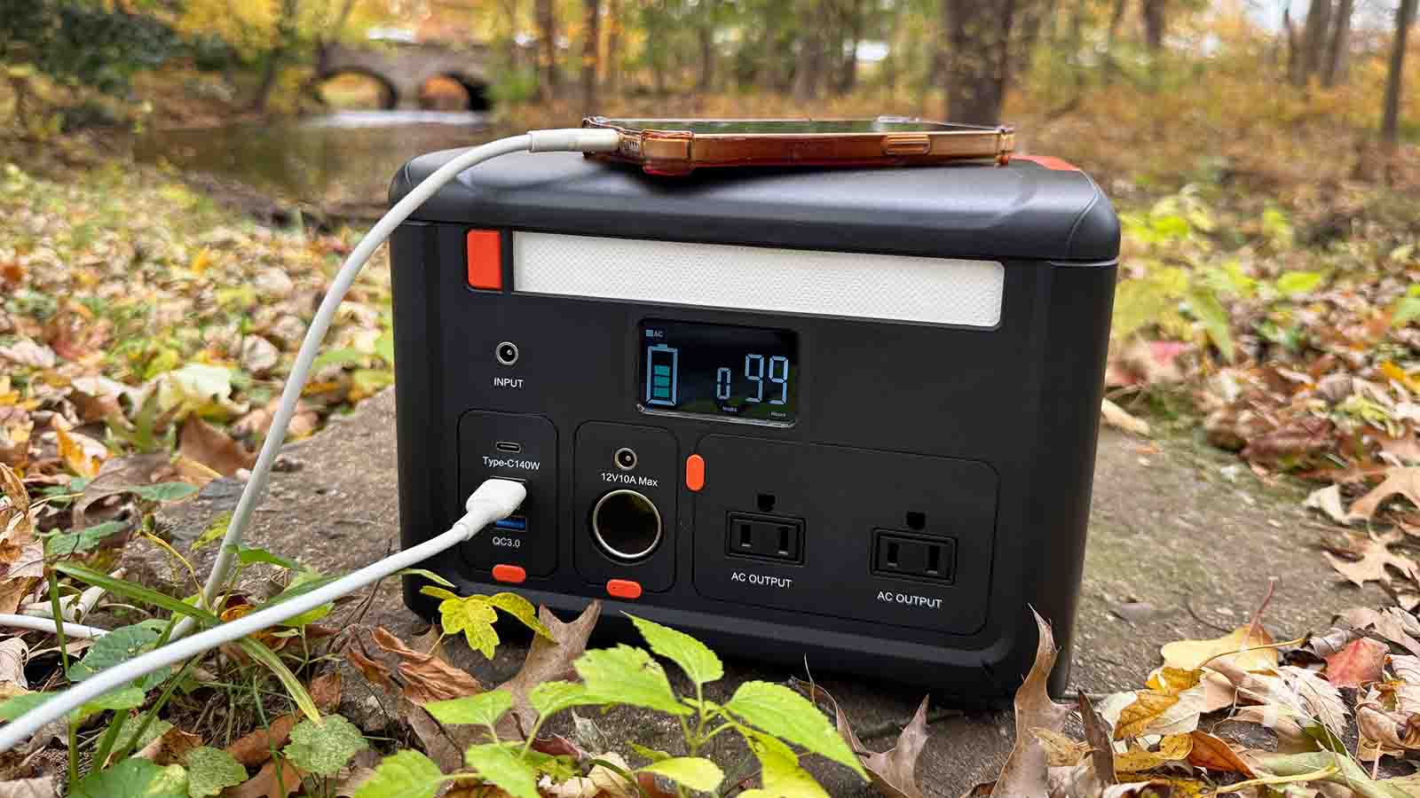 Cybpulte C601 Portable solar power generator charging device outdoors in autumn forest.