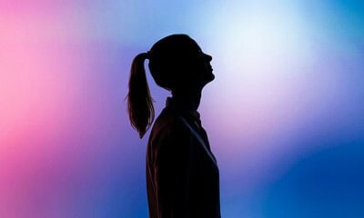Silhouette of a woman with a ponytail against vibrant pink and blue gradient background, emphasizing technology, innovation, and modern lifestyle themes for SEO optimization.