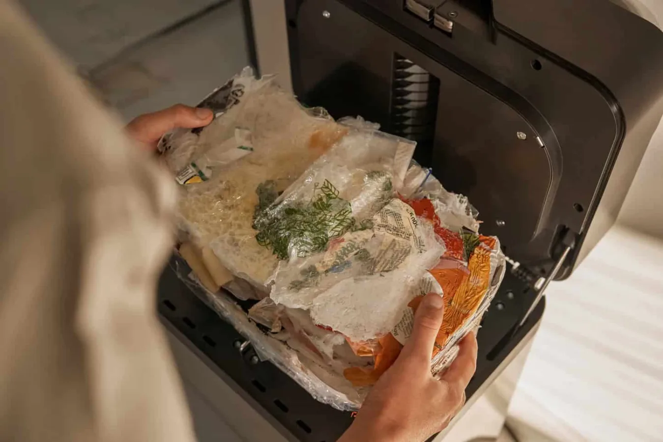 Person placing food waste in compost machine