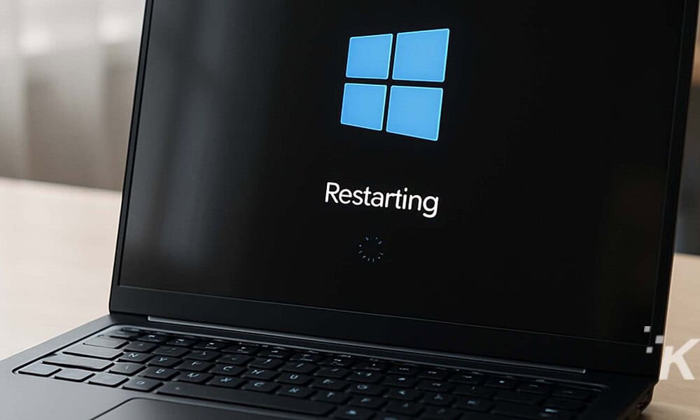 Blue Windows logo on a black laptop screen showing restarting message.
