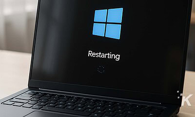 Blue Windows logo on a black laptop screen showing restarting message.