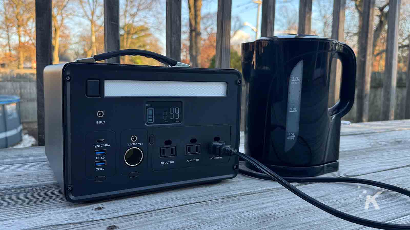 Portable power station connected to electric kettle outdoors.