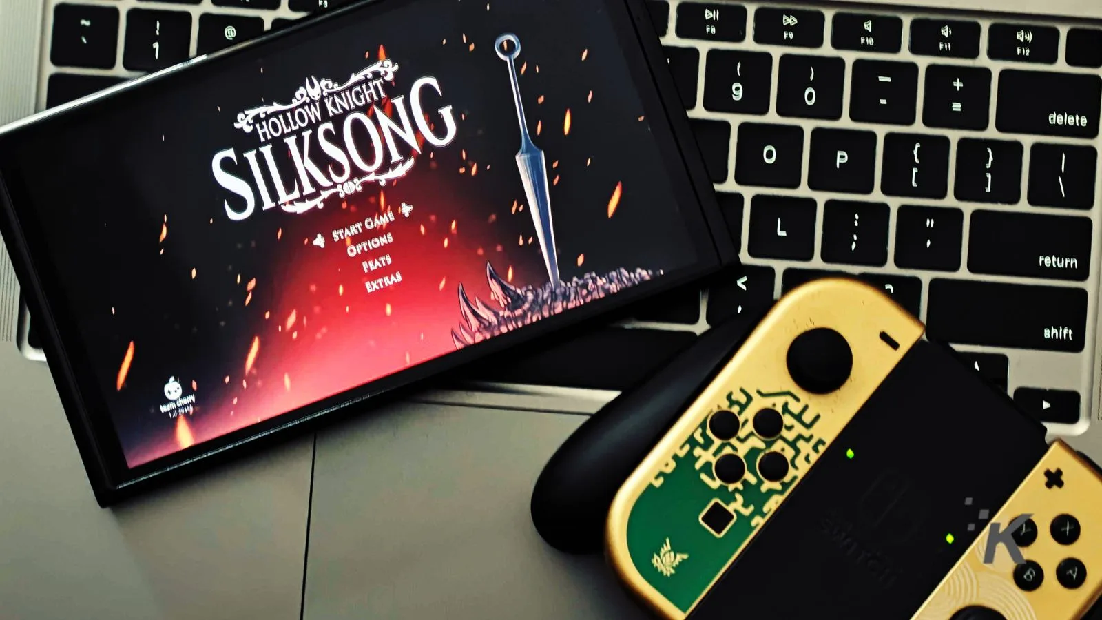 Vivid image of the Silksonic game menu displayed on a smartphone screen, with Nintendo Switch controllers and a keyboard in the background, highlighting gaming accessories and entertainment technology.