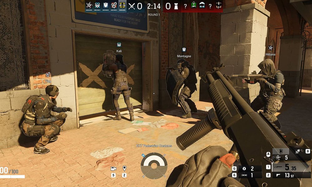 High-action scene from tactical first-person shooter video game featuring team members positioned outside a building.