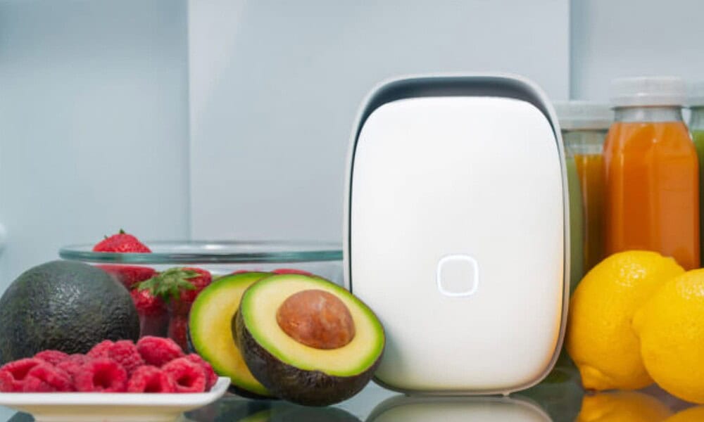 A sleek, modern smart refrigerator with a digital interface, surrounded by fresh fruits like avocados, lemons, berries, and bottles of juice, showcasing advanced kitchen tech.