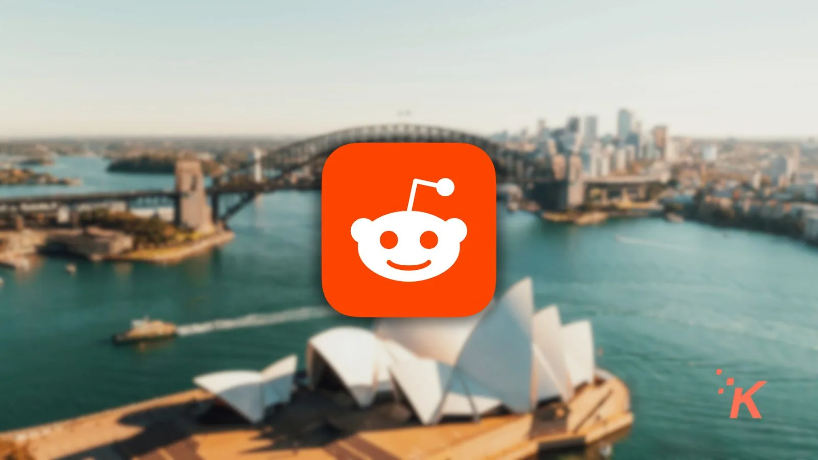 Reddit logo displayed prominently against a blurred background of Sydney’s iconic bridge and Opera House, emphasizing social media, discussion forums, and internet culture.