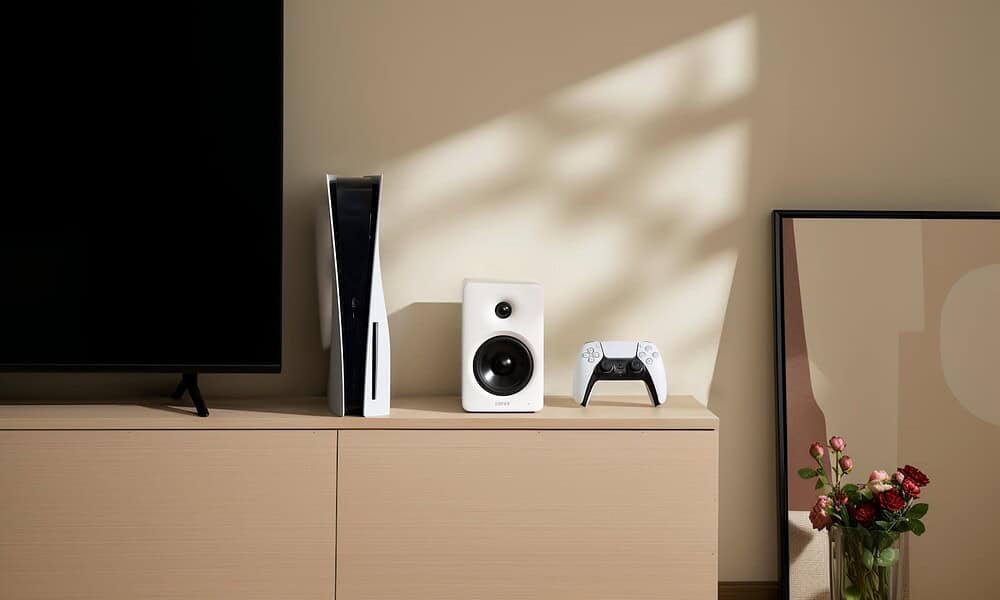 PS5, edifier speaker, and controller on wooden cabinet
