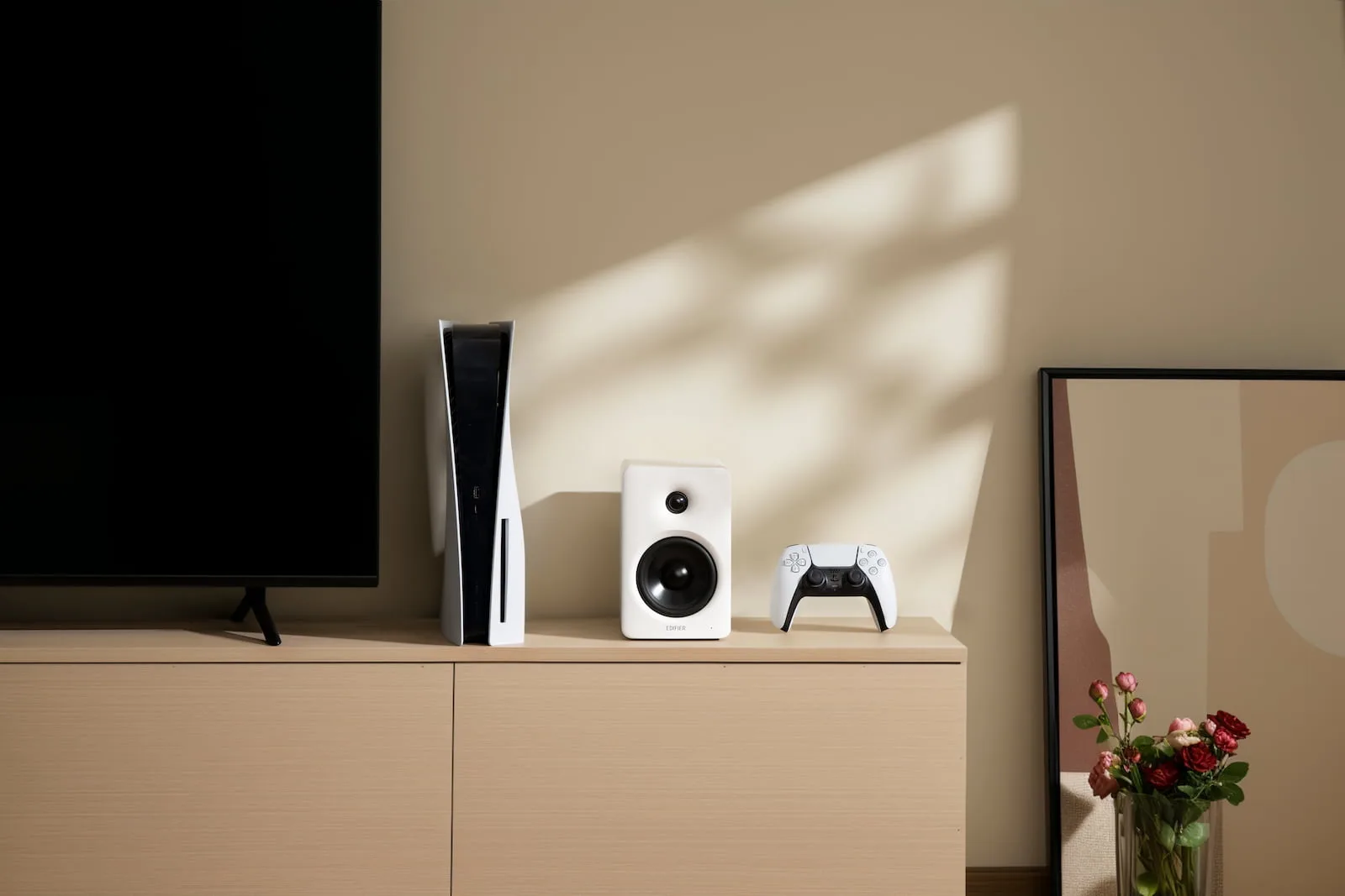 PS5, edifier speaker, and controller on wooden cabinet