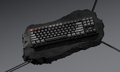 Floating mechanical Keychron keyboard on dark stone surface.