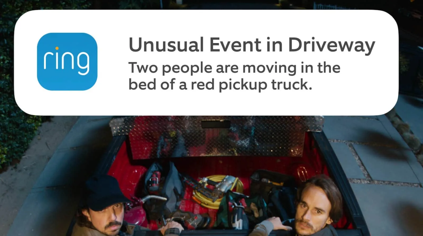 Ring notification alert capturing unexpected activity in driveway with two individuals in a truck bed.