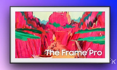 Brightly colored landscape painting with pink, green, and orange hues, showcasing digital art technology on a modern screen.