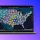 Interactive map showing data analytics and clustering markers across the United States on a laptop screen.